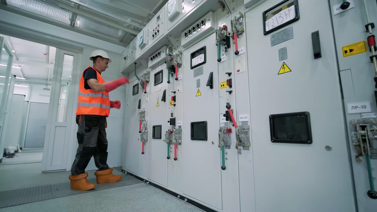 전기 엔지니어가 장비 제어 캐비에서 전기 시스템을 검사합니다.