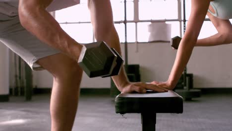 fit people lifting dumbbells in gym