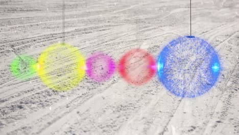 Animation-of-colourful-baubles-over-snow-covered-ski-slope