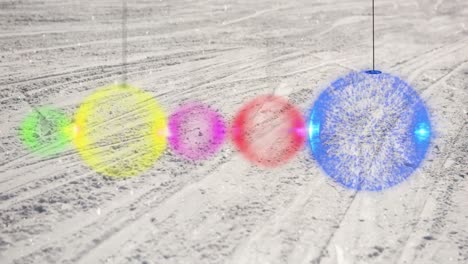 animation of colourful baubles over snow covered ski slope