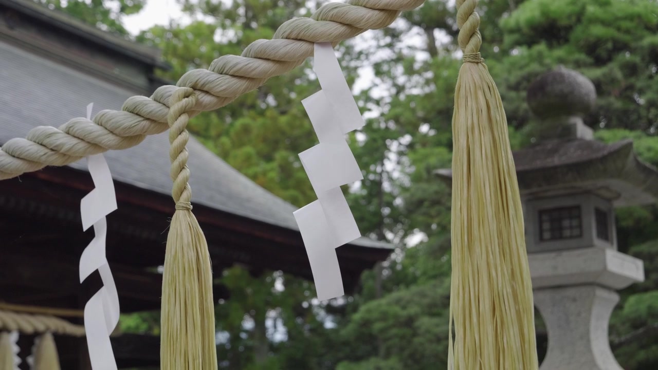 Lähikuva perinteisestä köydestä japanilaisen pyhäkön sisäänkäynnillä hidastettuna.
