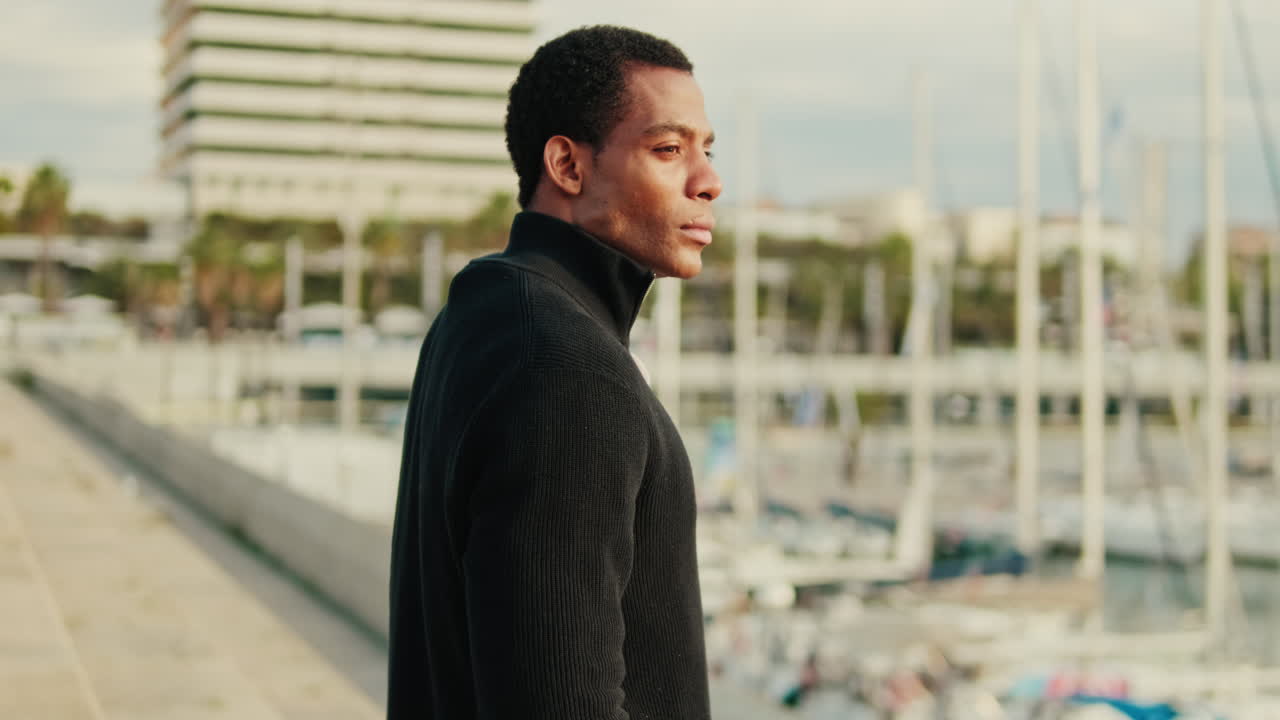 Young Dark-Skinned Man Standing Thoughtfully by a Marina