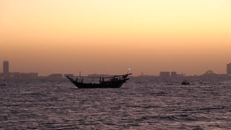 Dhow-árabe-Tradicional-En-El-Mar,-Fondo-Palm-Jumeirah-Dubai