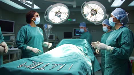 a team of surgeons in surgical scrubs prepares for an operative procedure in a modern hospital operating room with advanced medical equipment