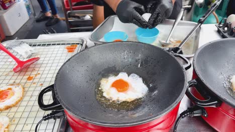 cooking fried eggs at a street food stall