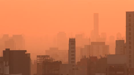 Building-in-São-Paulo-at-dawn-in-spring,-orange-sun-4k-long-lens-tele