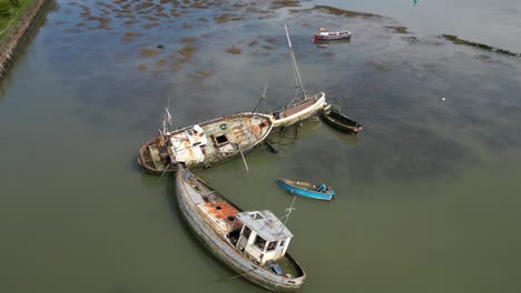 orbit of derelict shipwrecks in muddy water of the river wyre at fleetwood docks lancashire uk