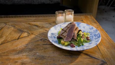 tuna is served on a wooden table with candles