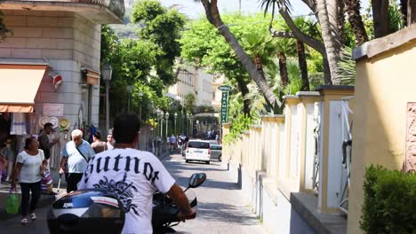 scooter passing pedestrians in a narrow alley