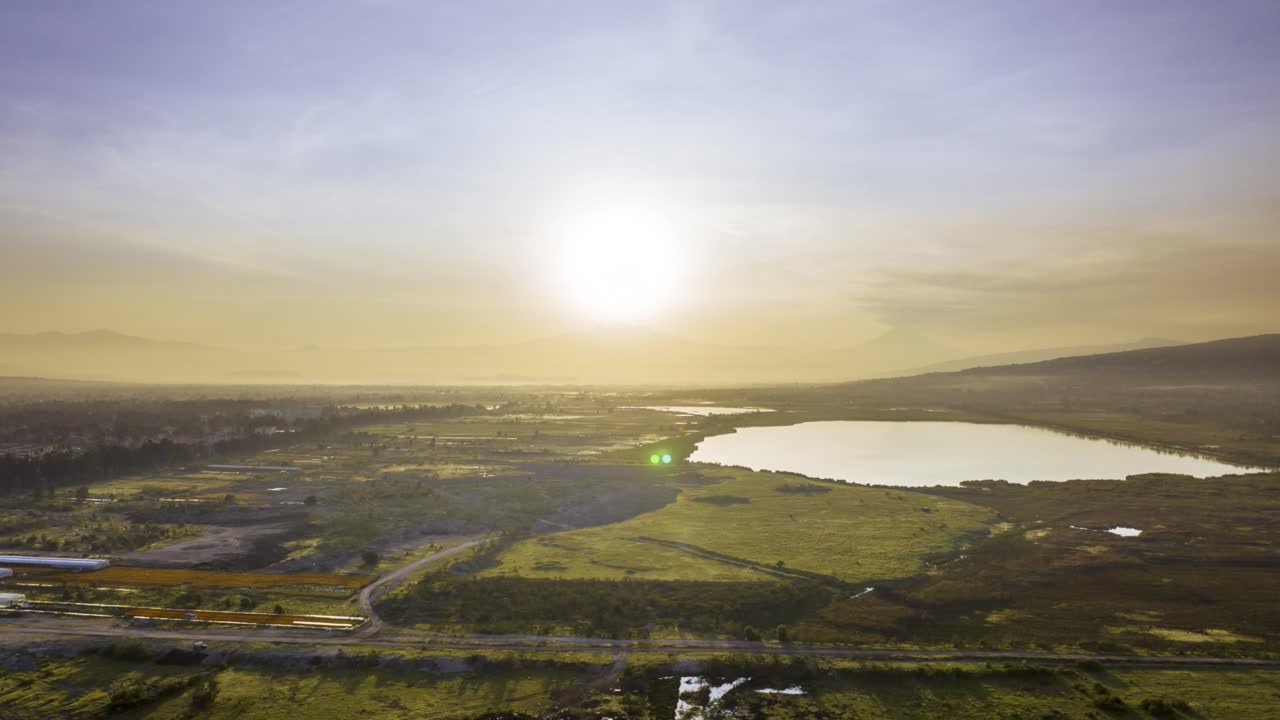 멕시코에서 해가 지는 동안 넓은 땅으로 둘러싸인 아름다운 호수의 영화적 소트