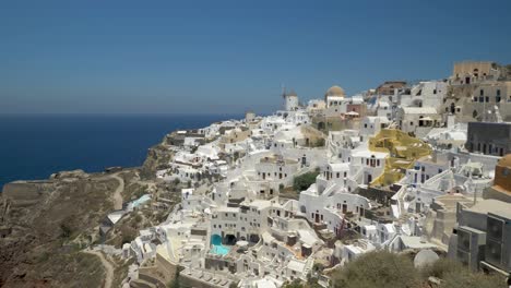 Vista-Icónica-Sobre-Oia-Santorini-Con-Molinos-De-Viento-Y-Casas-Blancas,-Grecia