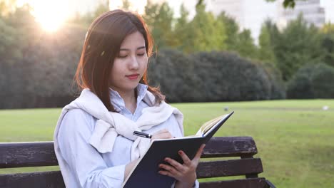 4k:beautiful asian girl reading book at park,shanghai,chin