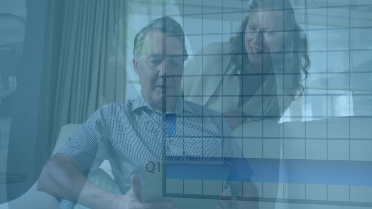 una feliz pareja caucásica mayor usando una tableta y hablando en su sala de estar