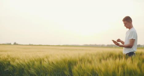 Male-Farmer-Using-Digital-Tablet-In-Field-