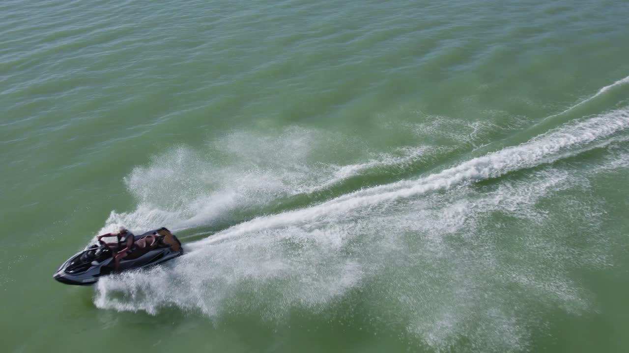 vista aérea de drones sobre una persona montando y acelerando en jet ski sea doo