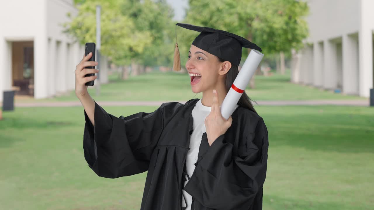 Ragazza indiana neolaureata felice che si scatta selfie.