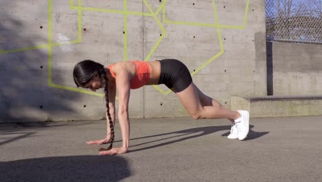 mujer haciendo tablón alto con rutina de ejercicios de elevación de rodilla a codo