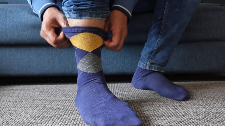 Man putting on socks and jeans
