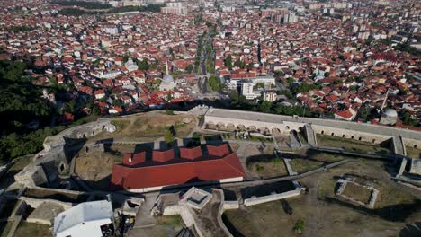 flying over beautiful city of prizren, revealing ancient castle with stone walls on hill