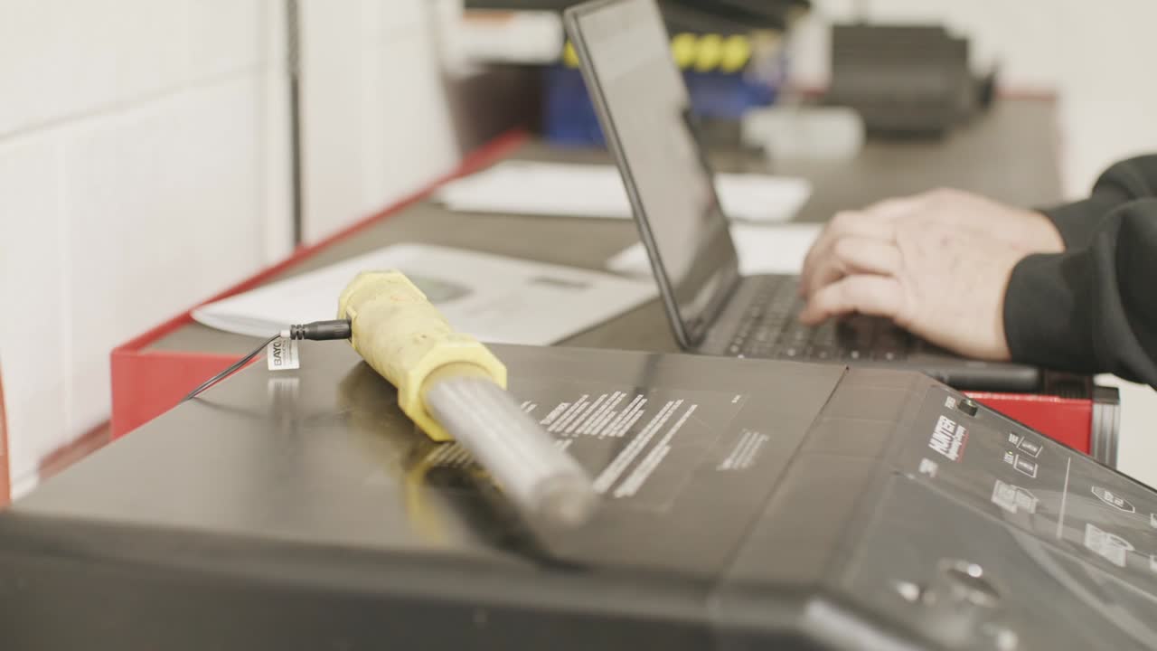 Auto mechanic typing on a computer with video close up in slow motion.