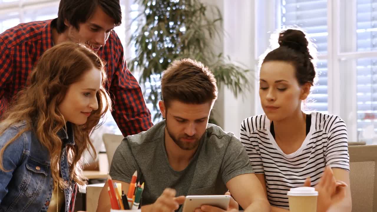 ejecutivos de negocios masculinos y femeninos discutiendo sobre tableta digital en su escritorio