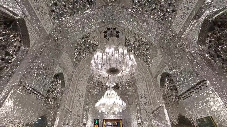 Intarsi a specchio elaborati e lampadari di cristallo all'interno di una moschea ornata