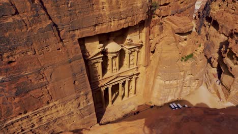 Khaznet,-the-Treasury,-the-famous-historic-UNESCO-heritage-site-carved-into-sandstone-at-Petra,-Jordan-seen-from-a-viewpoint-above