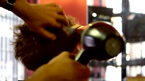 hombre usando secador de cabello en el cabello del cliente 4k