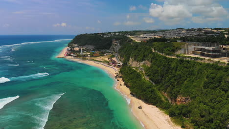 Descending-drone-capturing-a-beautiful-scenery-of-forested-cliffs-and-oceanic-waves