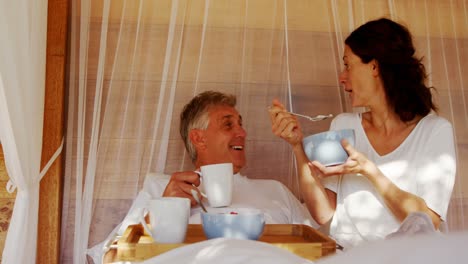 couple having breakfast in canopy bed 4k