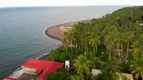 aerial drone shot passing over a fishing village with filipino boats on exotic island tropical paradise with palm trees in the philippines 4k