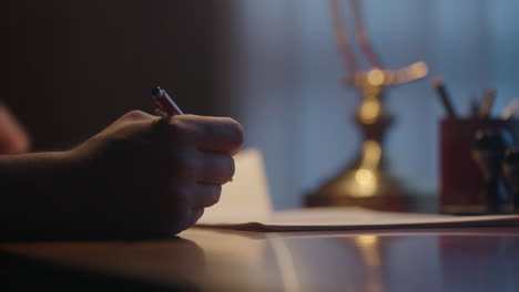 person writing at a desk at night