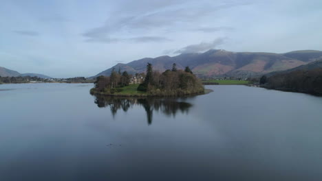 Drone-Aéreo-Disparó-Sobre-El-Lago-Derwentwater-Keswick-Con-La-Casa-De-La-Isla-De-Derwent-Y-Skiddaw-En-Tiro-Al-Amanecer-En-Un-Día-Soleado-Con-Nubes-Distrito-De-Los-Lagos-Cumbria-Reino-Unido