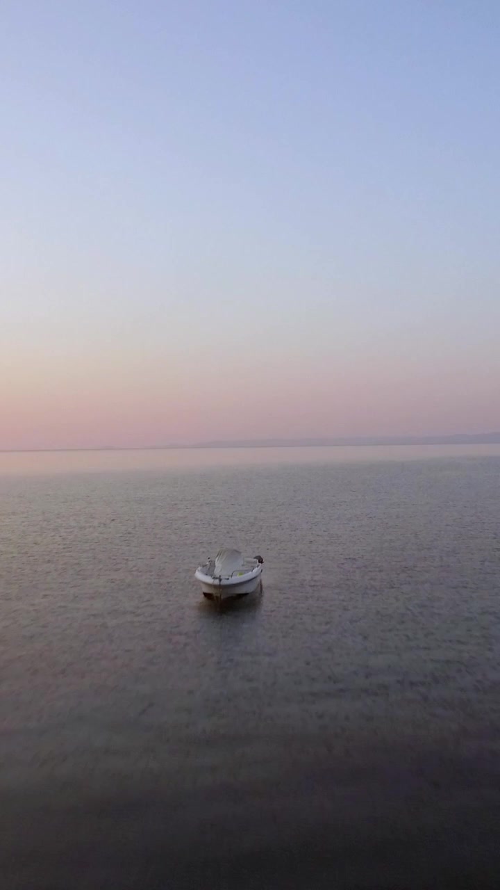 Vista aerea serale di un vasto mare, barca solitaria e skyline