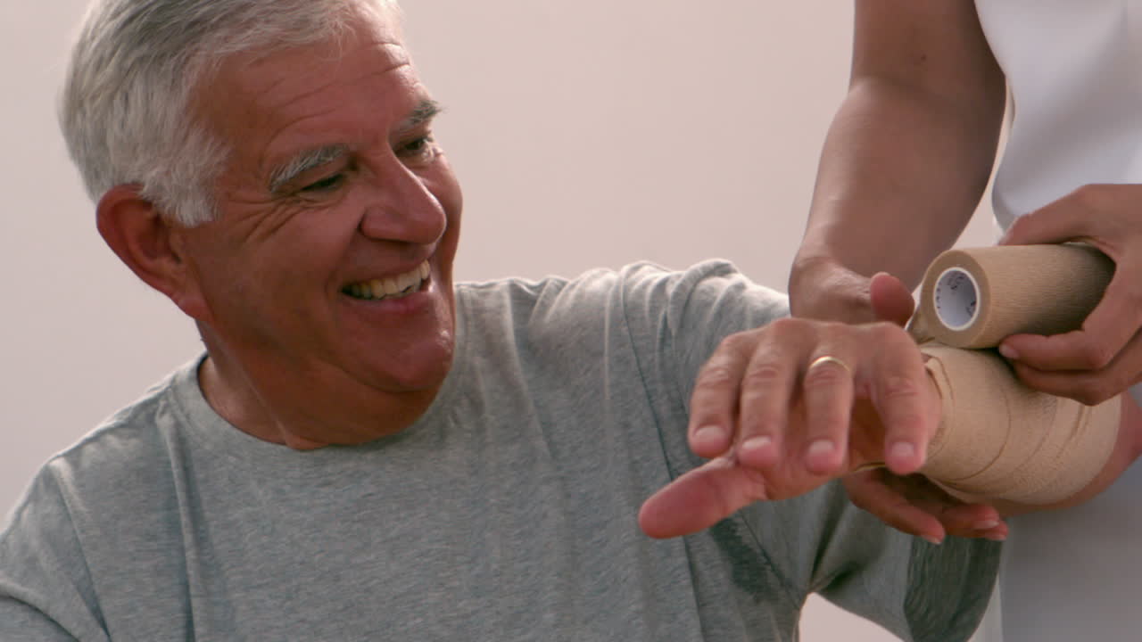 피지오테라피스트가 노인의 팔을 는 것