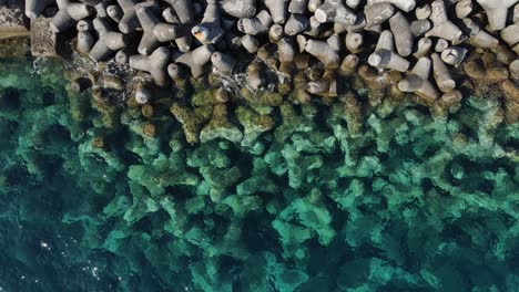 Ein-Blick-Von-Oben-Auf-Das-Meer-Und-Eine-Wellenbrecherstruktur-Eines-Hafens