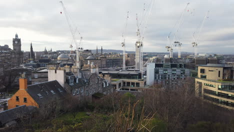 Blick-Auf-Die-Skyline-Von-Edinburgh-Vom-Calton-Hill-Schwenk-Von-Rechts-Nach-Links-Von-Einigen-Großen-Industriekränen-In-Der-Nähe-Von-John-Lewis-Hinüber-In-Richtung-Princes-Street-An-Einem-Bewölkten-Tag,-Edinburgh,-Lothian,-Großbritannien