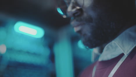 close-up of a man with glasses and beard in blue light