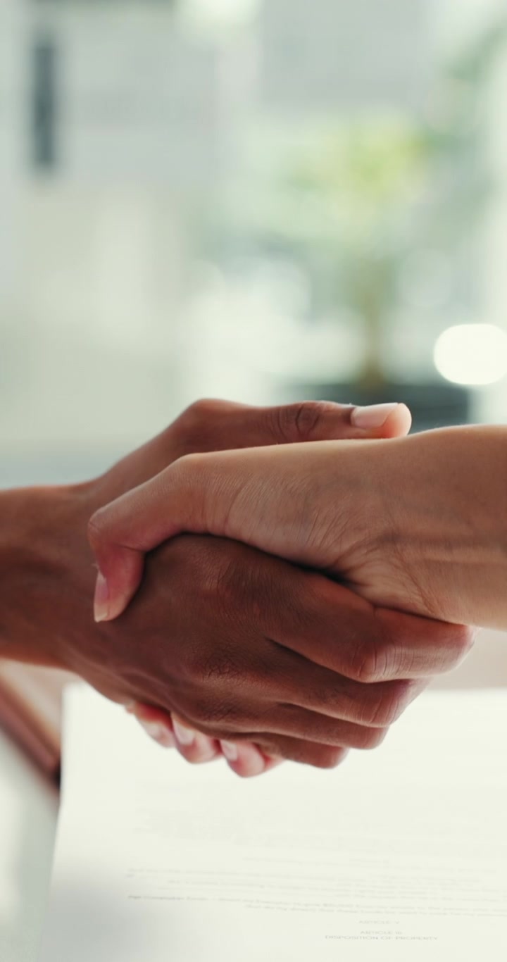 Business Professionals Shaking Hands Over Contract in Office