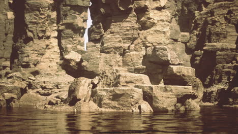 scenic view of rocky cliffs rising from calm waters in a natural setting