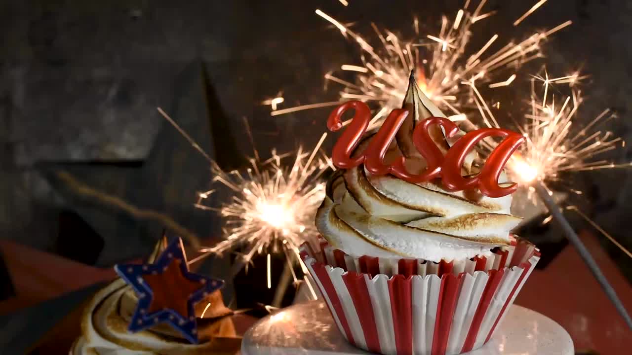 искры, взрывающиеся за красно-бело-голубым кексом с поджаренной меренгой на вершине