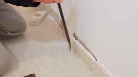 high-angle shot of flat pry bar removing tile skirting