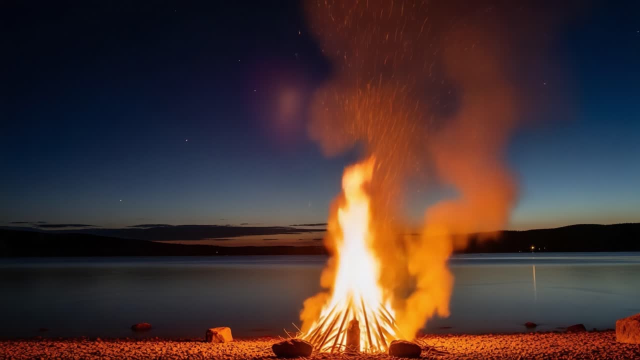 A mesmerizing bonfire illuminates the night by the water's edge, sending sparks into the starry sky, creating a warm and inviting atmosphere for gathering and reflection
