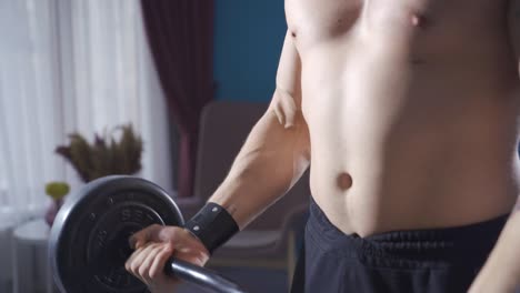 young athletic man with a big and fit body does barbell curls.