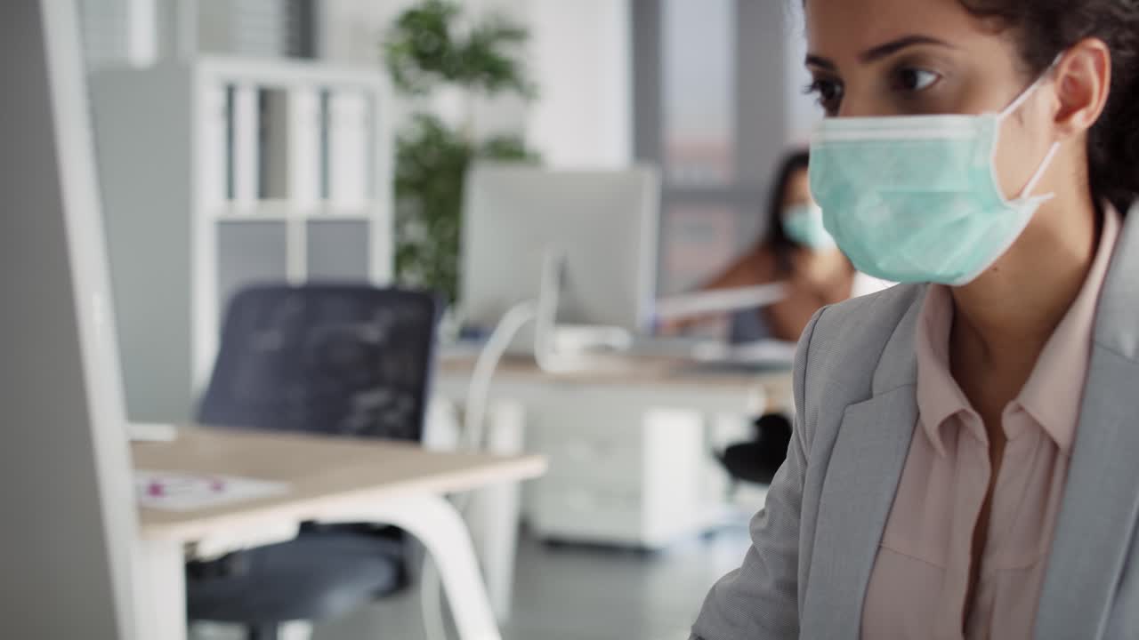Video of women in protective face mask working in office