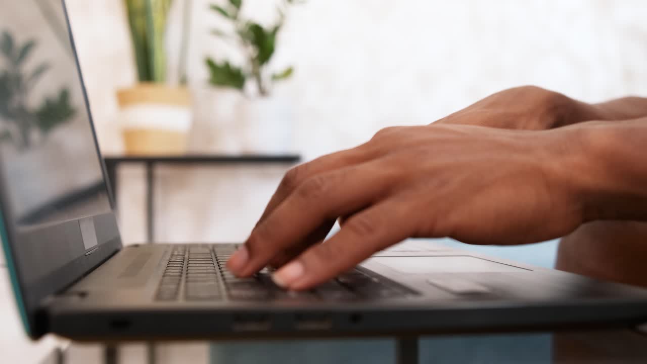 Close-up of hands typing on a laptop keyboard