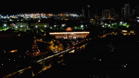 aerial view of capital city skyline of manila philippines with night lights of metropolis train passing national museum of fine arts and historical intramuros walled city
