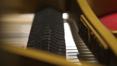 closeup of an inside of a piano hammers hitting strings with shallow focus in 4k