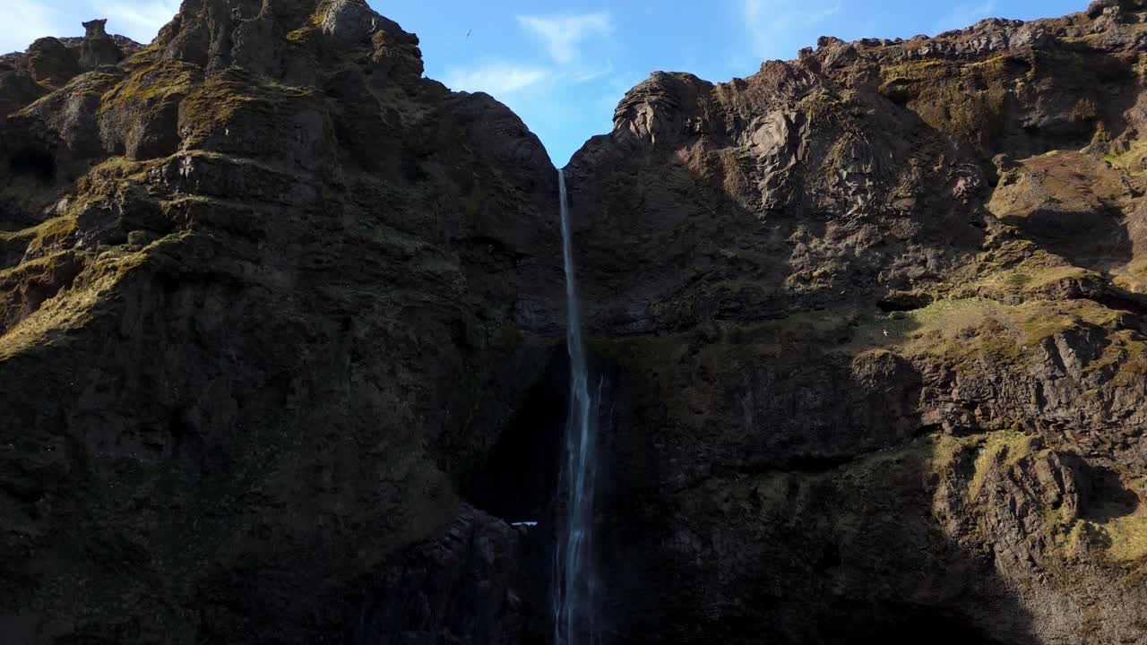 aerial view of waterfall in Fjaðrárgljúfur feather river canyon Iceland, drone close up with birds flying around