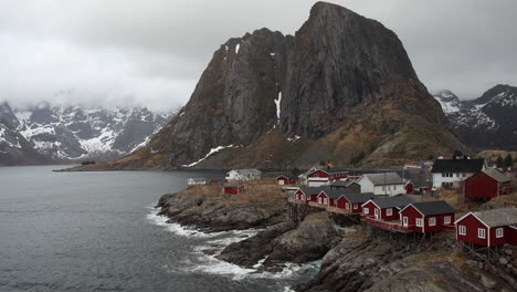 Festhaltinden-mountain-at-Hamnoy-in-northern-Norway---Handheld-static-with-ocean-waves-slowly-splashing-up-against-rocky-shoreline